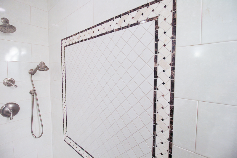 Custom shower with a specific pattern for an elegant look, using crema marfil marble intertwined with empadora dark marble.