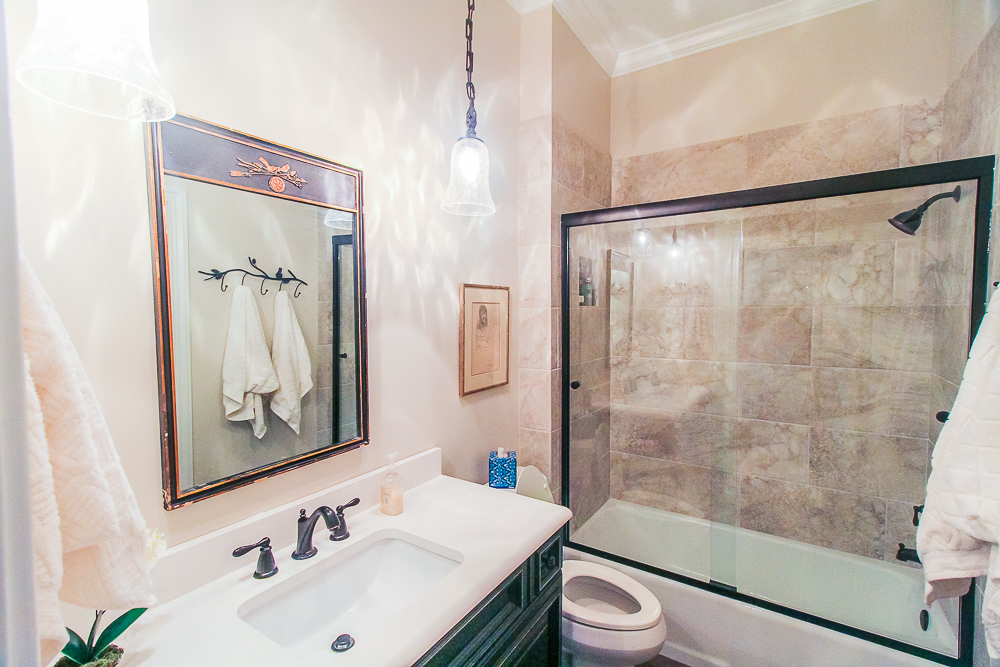 Large vanity with a distressed finish is illuminated with pendant lights.