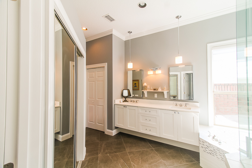 Large white wall mount look vanity is used here with abundant storage.